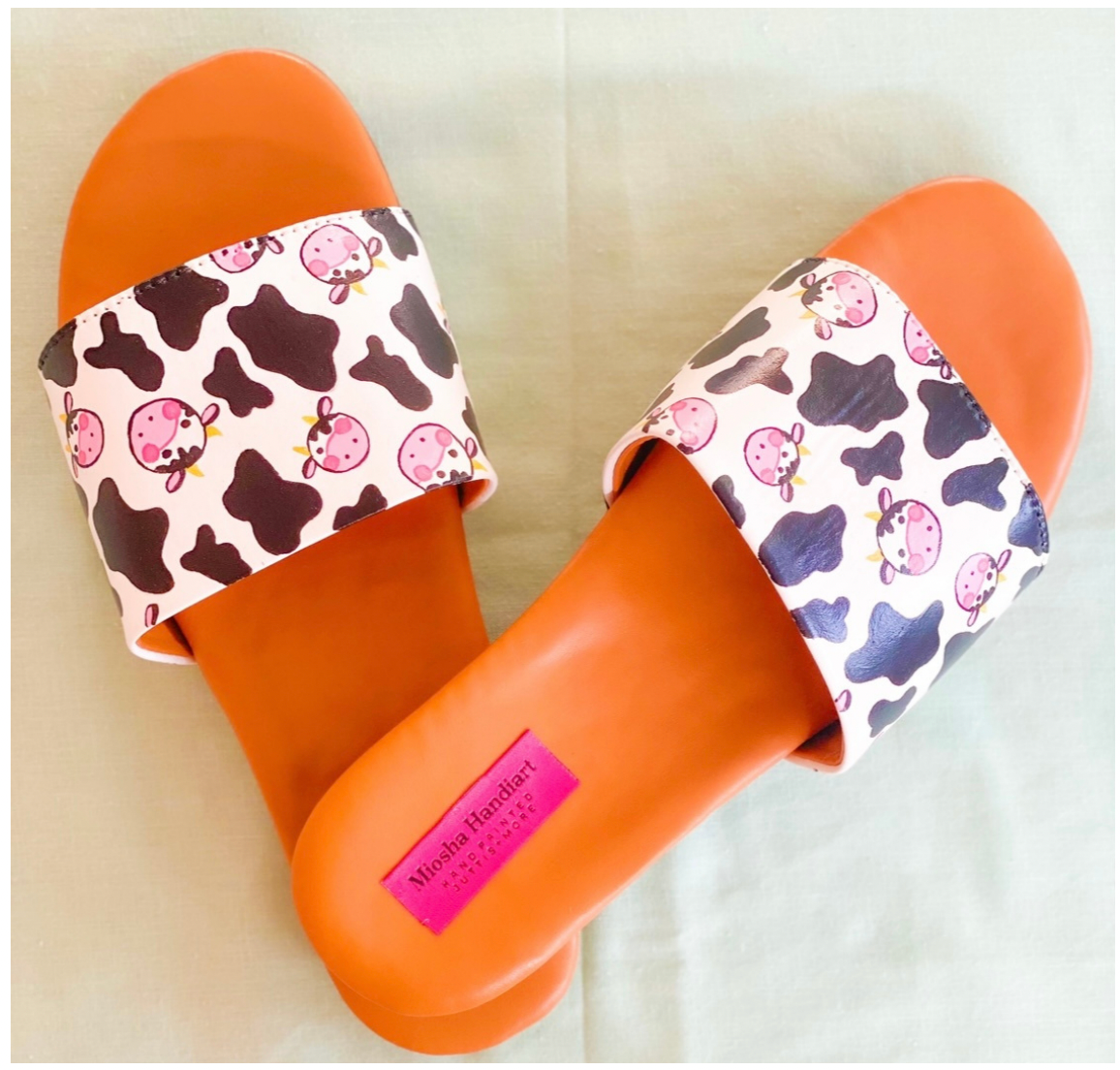 Introducing our Handpainted Cow Print Juttis! These shoes feature a unique and eye-catching handpainted design that is sure to make a statement. Made with high-quali